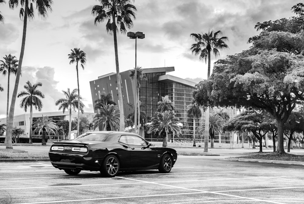 a black and white photo of a car parked in a parking lot