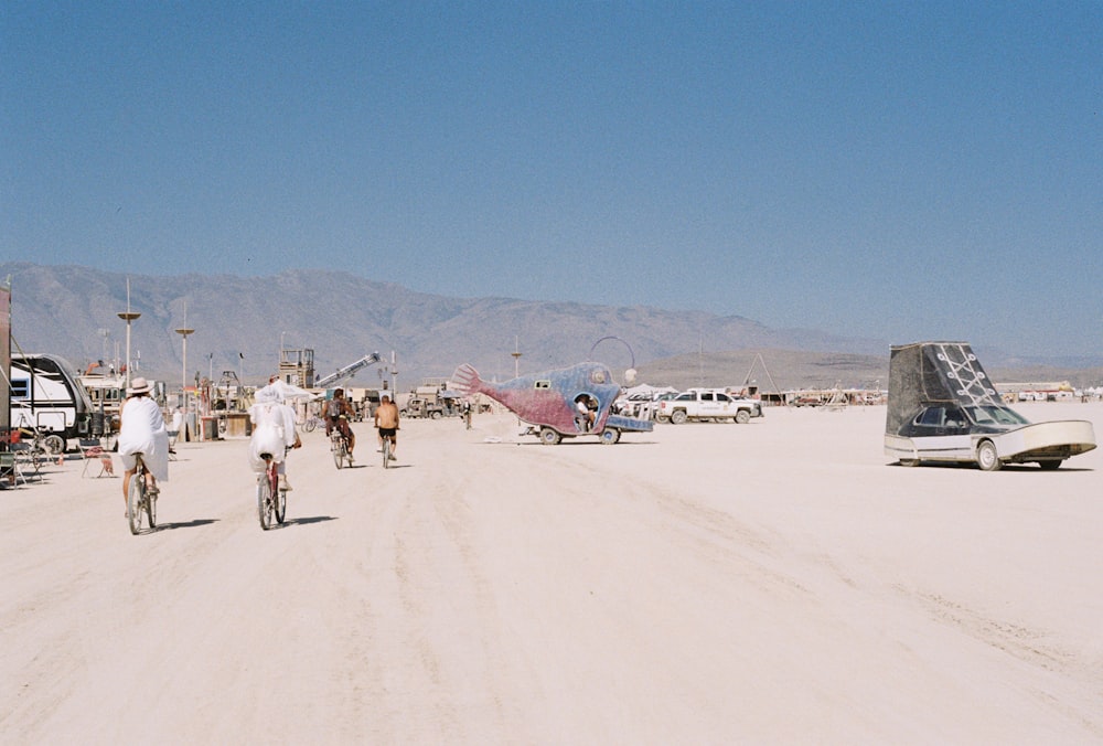 a group of people riding bikes down a dirt road