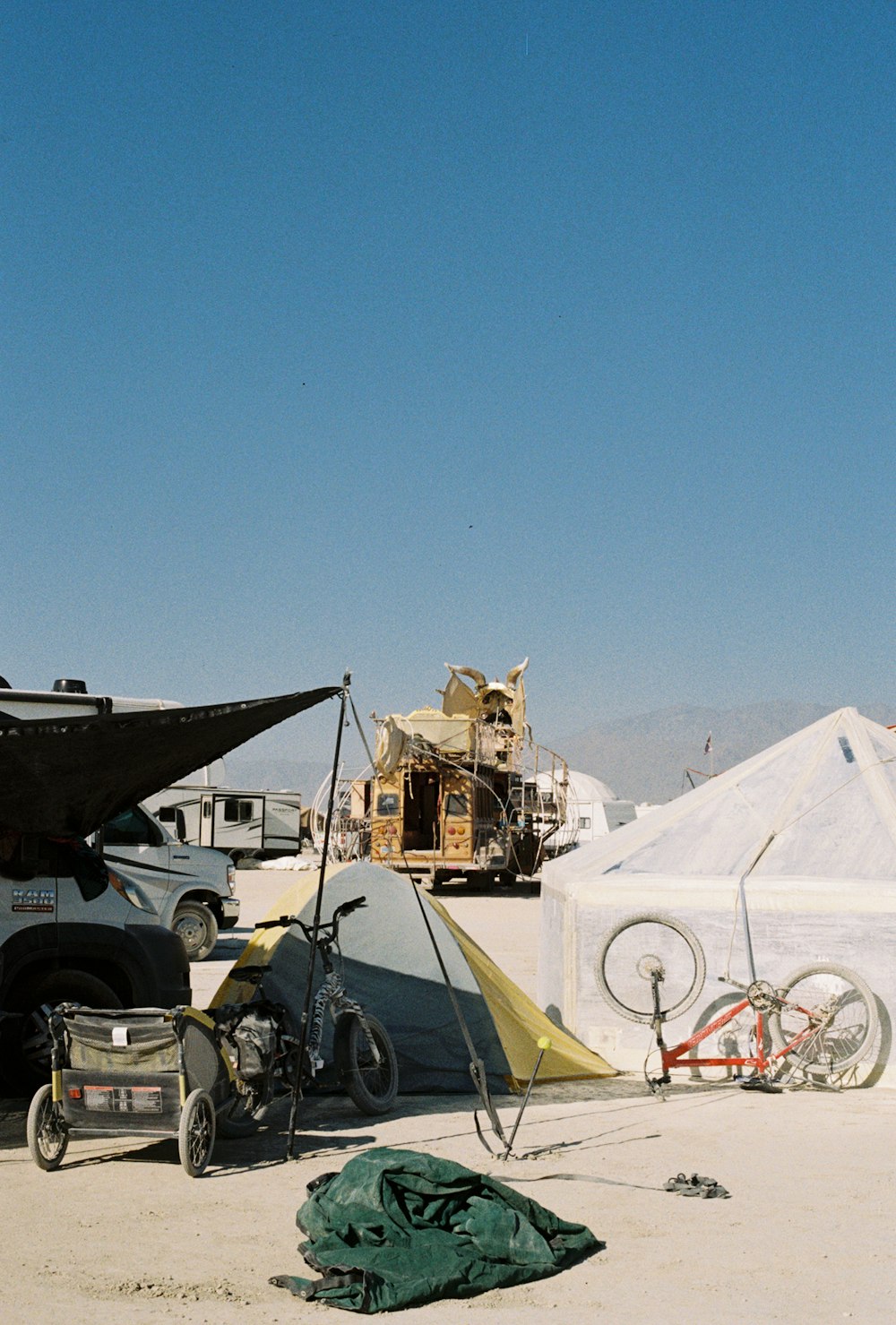 a tent, bike, and camper in the desert