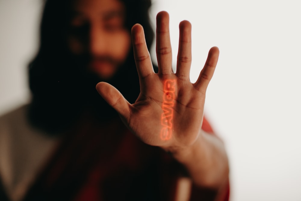 a man with a beard is holding his hand up