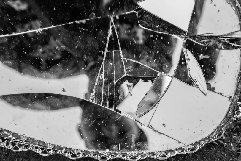 a broken mirror sitting on top of a sidewalk