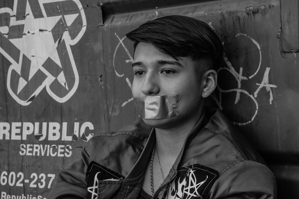 a young man with his face painted with graffiti