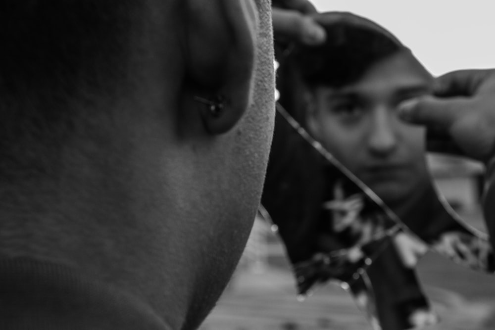 a man getting his hair cut by another man