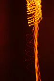Motion graphic still with fluid orange waves against a deep black background.