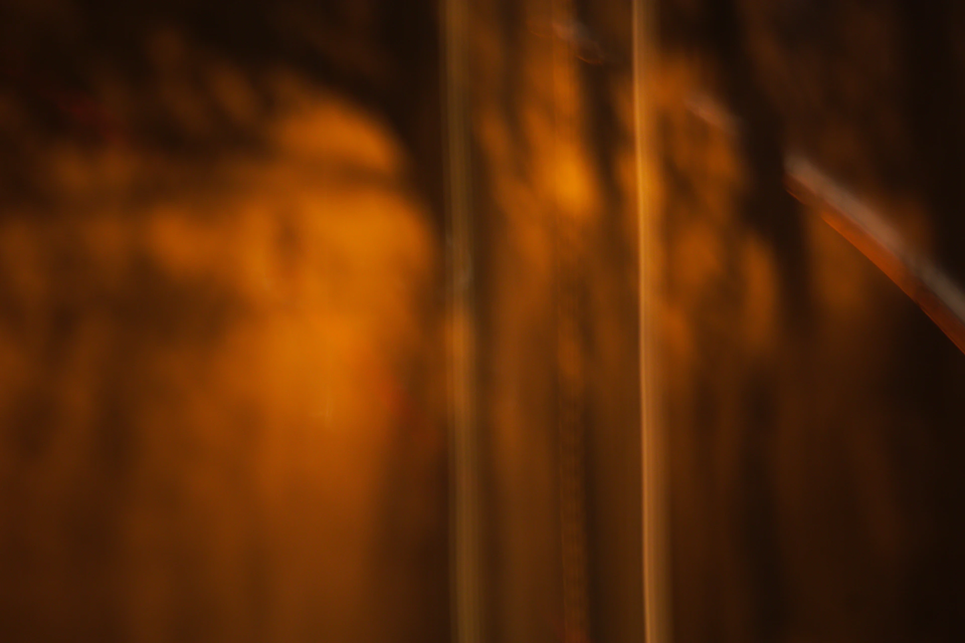 A moody photograph capturing the interplay of light and shadow on a vibrant abstract composition with hints of crimson and amber.