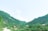 A scenic view of a rural village landscape with traditional houses and lush greenery.