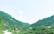 A scenic view of a rural village landscape with traditional houses and lush greenery.