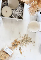 A peaceful corner with pranaluz packaging, dried flowers, and a lit candle creating a calming atmosphere.