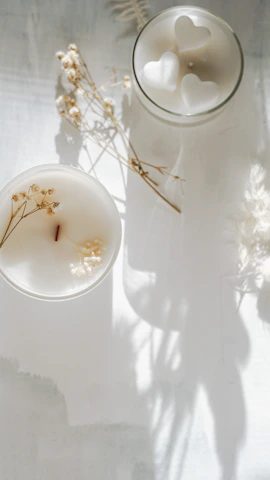 Minimalist display of candles with soft earth tones and delicate floral decorations.