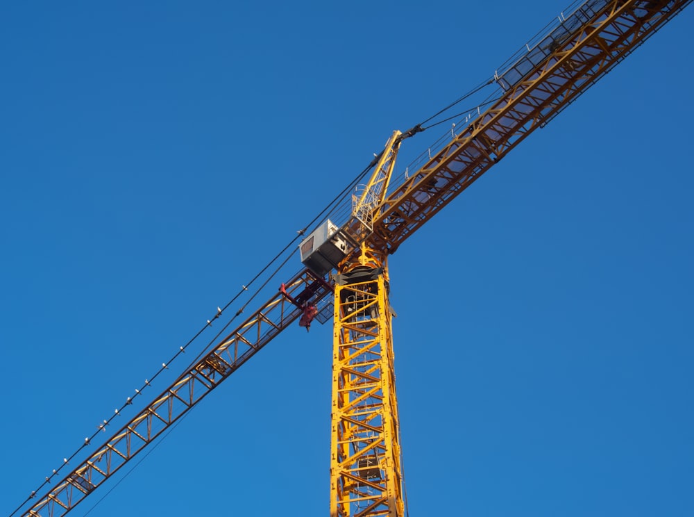 a yellow crane with a blue sky in the background