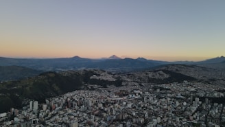 an aerial view of a city with mountains in the background