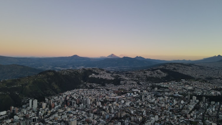 an aerial view of a city with mountains in the background