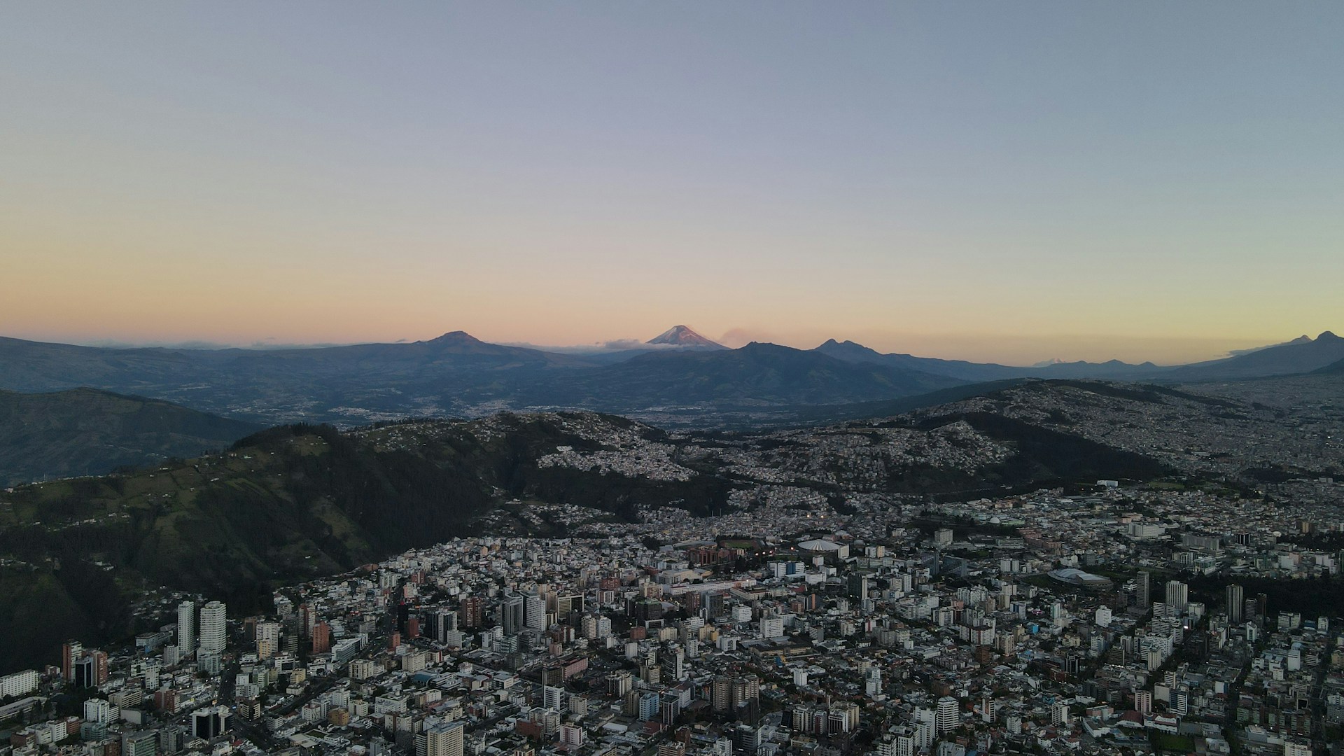 an aerial view of a city with mountains in the background