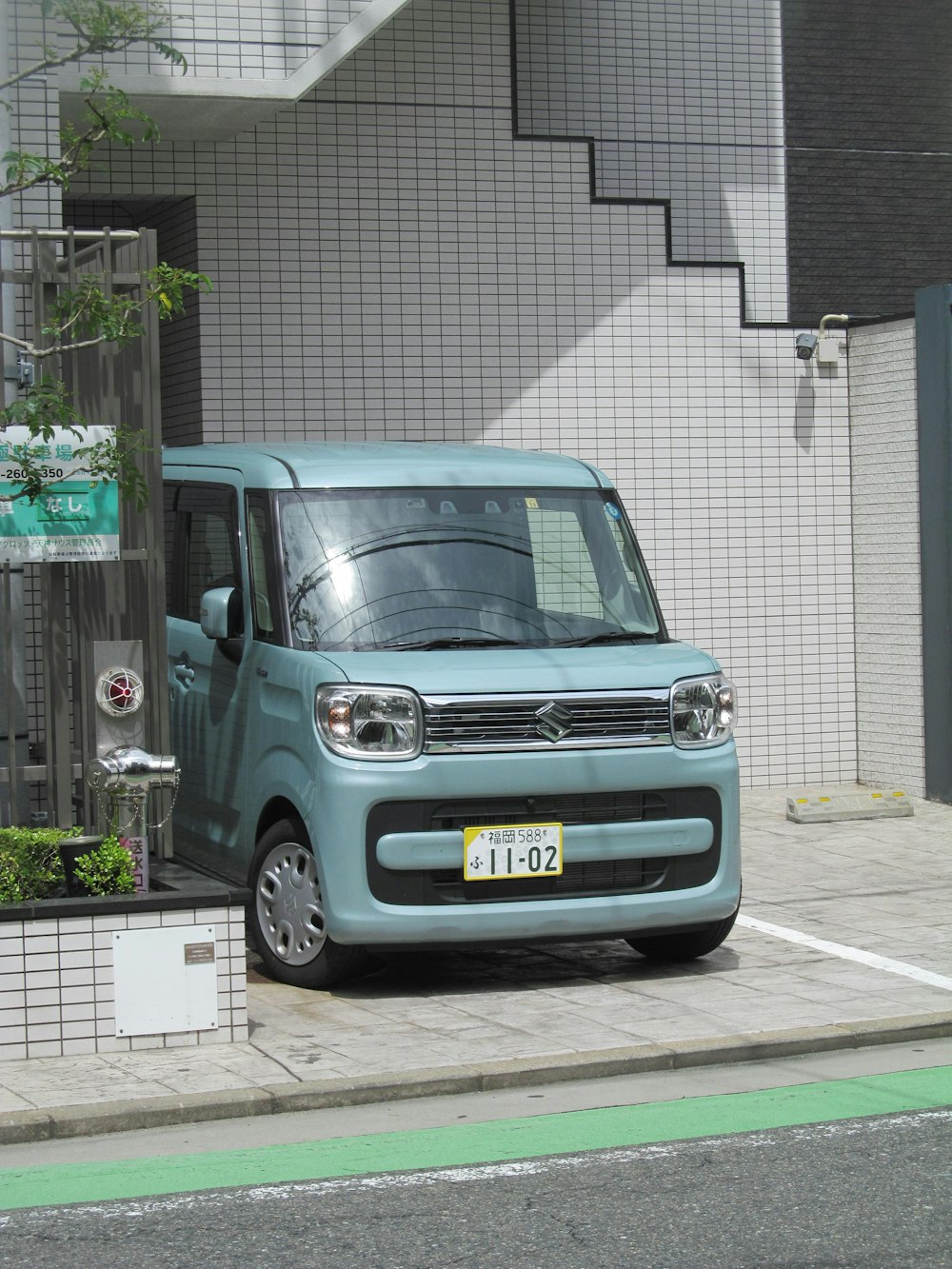 a small blue van parked in front of a building