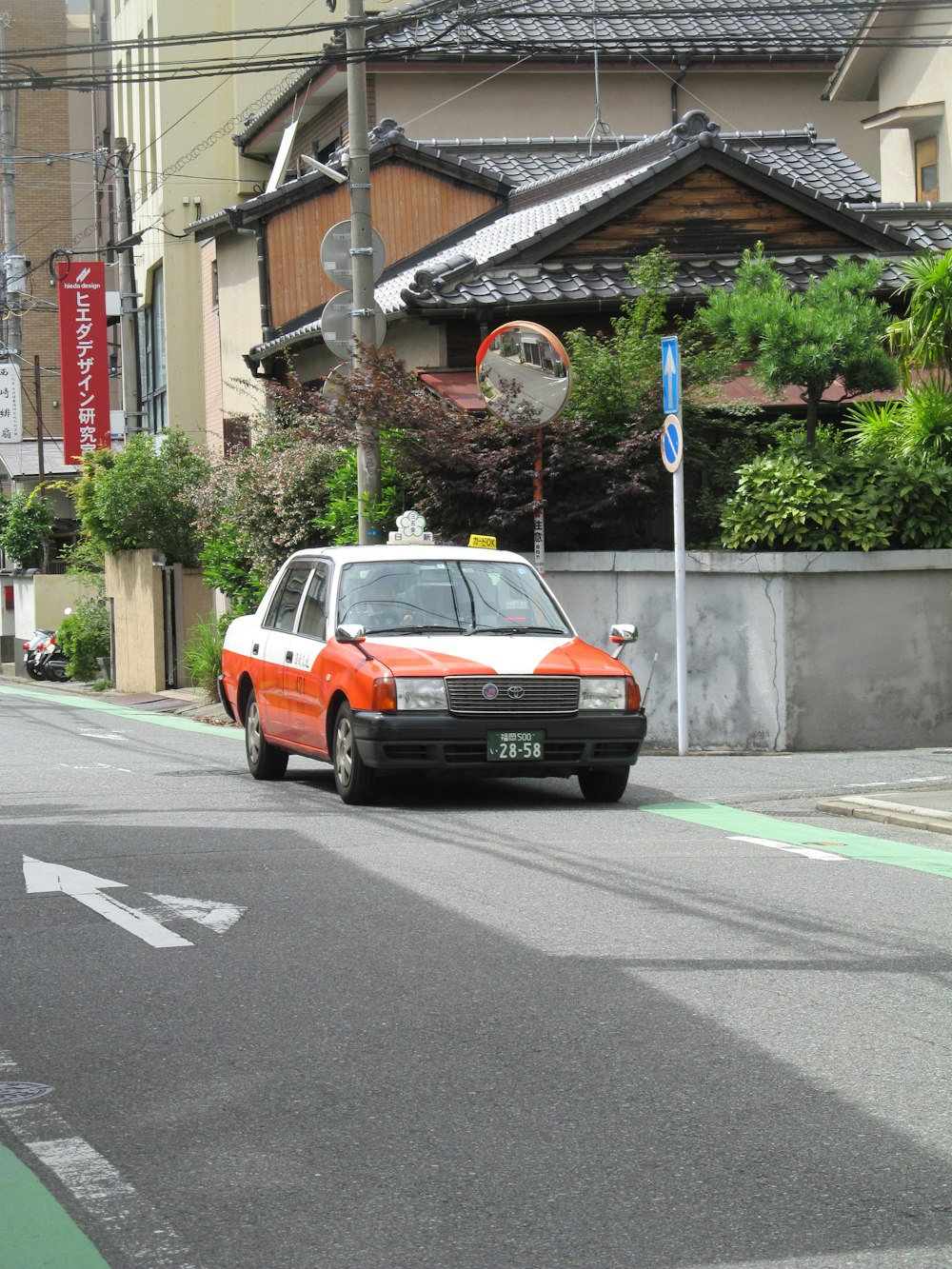 an orange and white car driving down a street