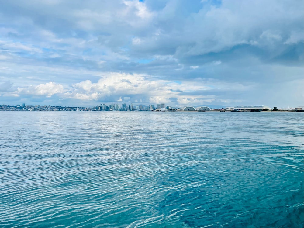 a body of water with a city in the background