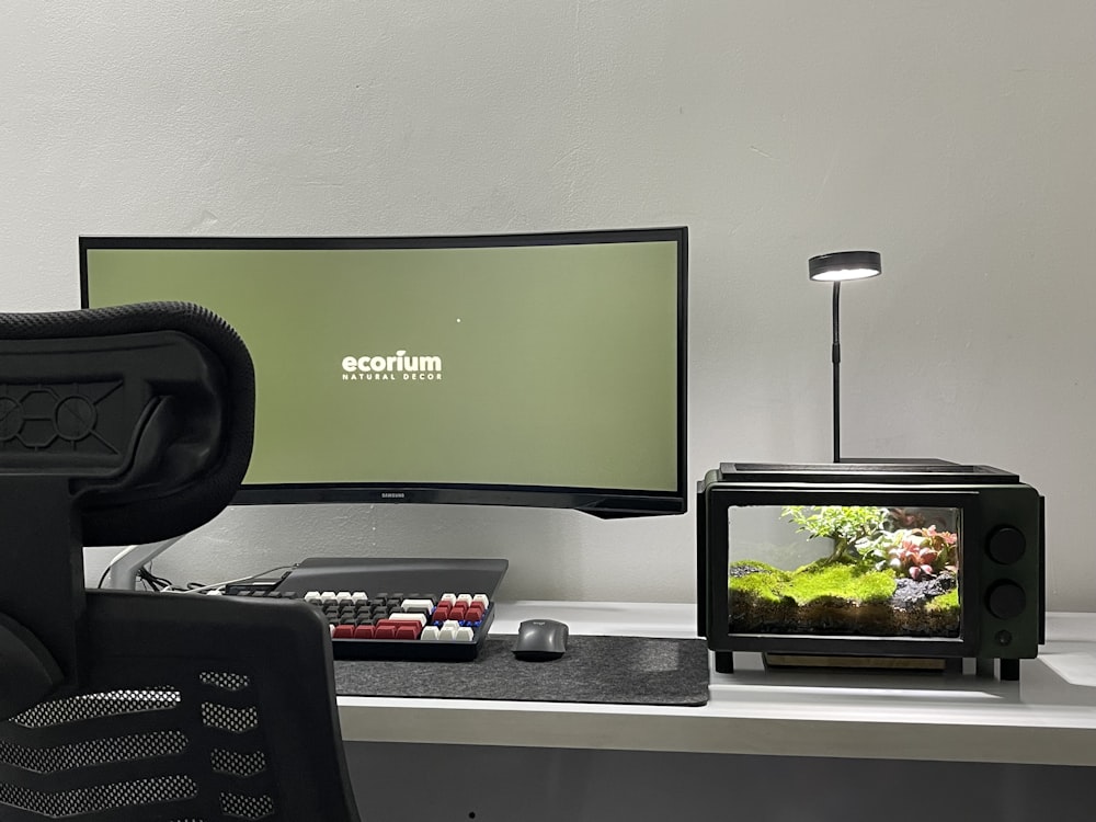 a desk with a monitor and a fish tank