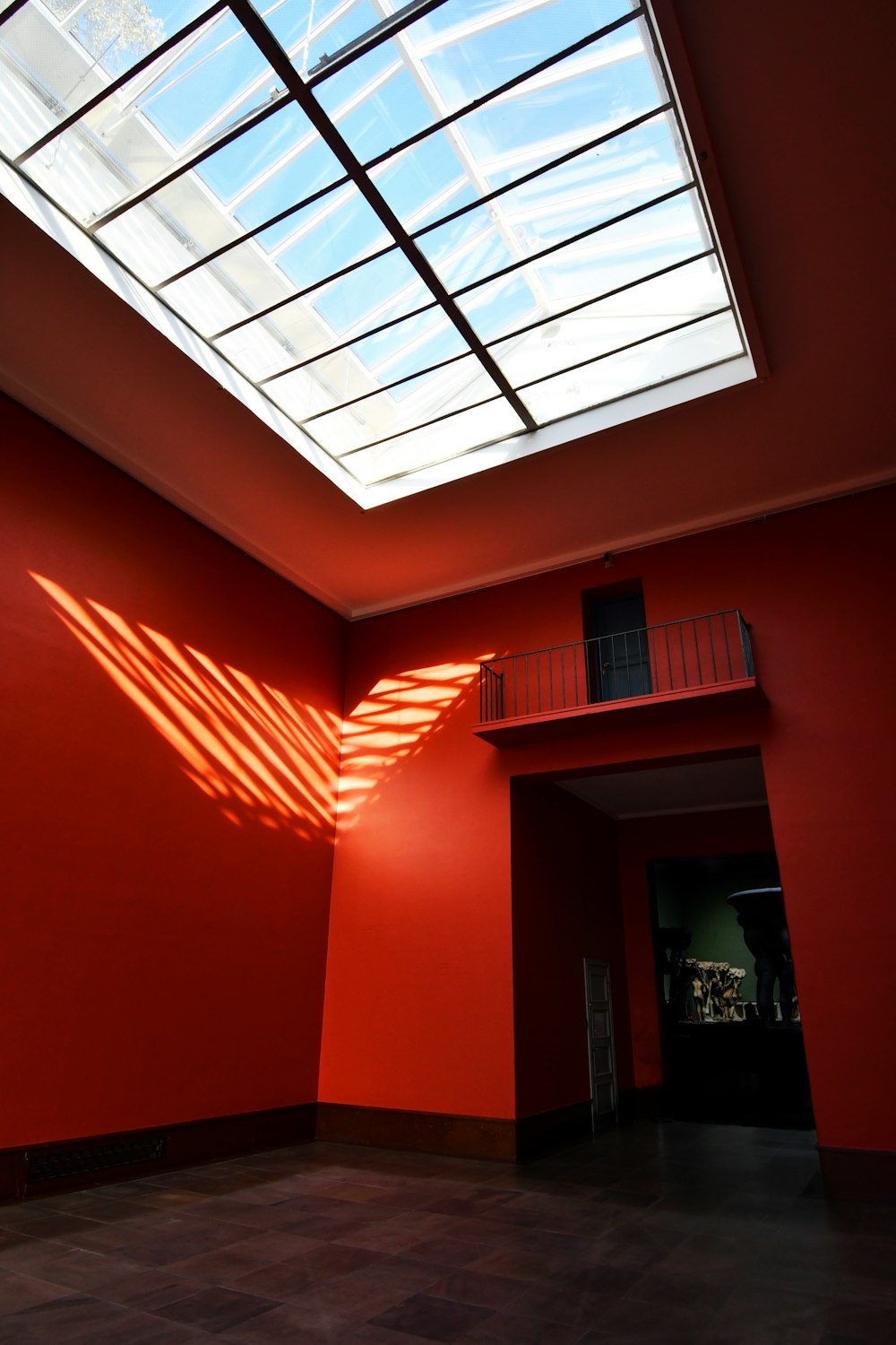a room with a skylight and a red wall