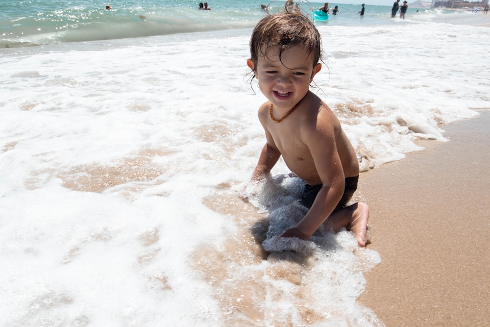 a young boy plays in the surf at the beach