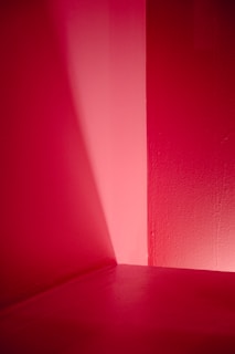 Minimalist composition featuring a single light source illuminating a dark room corner.