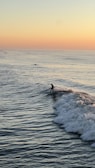 Smiling surfer enjoying the calm after catching waves at sunset.