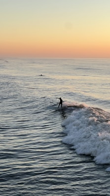 Smiling surfer enjoying the calm after catching waves at sunset.