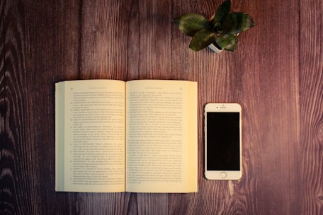 An open financial wellness ebook displayed on a tablet beside a pair of glasses and a plant