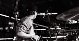a man playing drums in a dark room