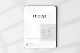 A digital mockup featuring a tablet with a minimalistic design. The screen displays a sleek interface with the word 'mocp' prominently at the top. Below it, there's information about features such as very realistic output and fully editable resolution. The background is clean and white, accented by soft shadows.