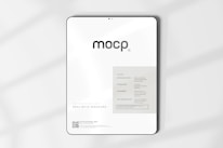 A digital mockup featuring a tablet with a minimalistic design. The screen displays a sleek interface with the word 'mocp' prominently at the top. Below it, there's information about features such as very realistic output and fully editable resolution. The background is clean and white, accented by soft shadows.