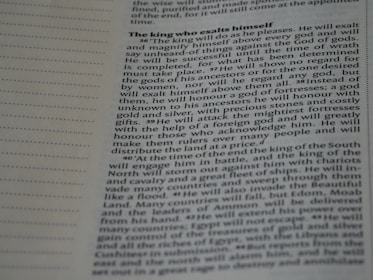 A close-up image of a page from a book or document, featuring English text printed in a block format. The text is densely packed with paragraphs and headings in bold, indicating different sections. The paper is light-colored, and the text is black with a readable, standard font. On the left side, there is a margin with evenly spaced dotted lines.