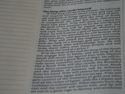 A close-up image of a page from a book or document, featuring English text printed in a block format. The text is densely packed with paragraphs and headings in bold, indicating different sections. The paper is light-colored, and the text is black with a readable, standard font. On the left side, there is a margin with evenly spaced dotted lines.