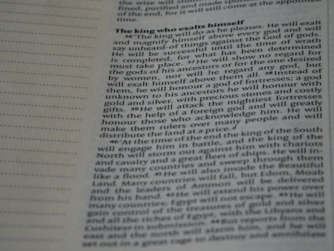A close-up image of a page from a book or document, featuring English text printed in a block format. The text is densely packed with paragraphs and headings in bold, indicating different sections. The paper is light-colored, and the text is black with a readable, standard font. On the left side, there is a margin with evenly spaced dotted lines.