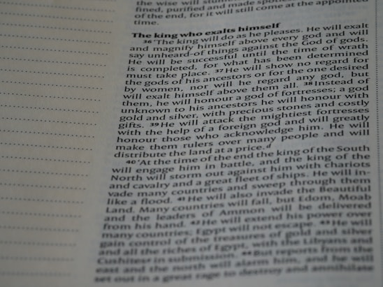 A close-up image of a page from a book or document, featuring English text printed in a block format. The text is densely packed with paragraphs and headings in bold, indicating different sections. The paper is light-colored, and the text is black with a readable, standard font. On the left side, there is a margin with evenly spaced dotted lines.