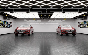 The same garage after renovation, featuring sleek floor coatings, custom storage cabinets, and bright lighting.