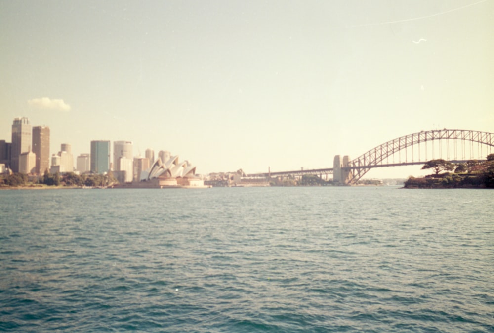 a large body of water with a bridge in the background