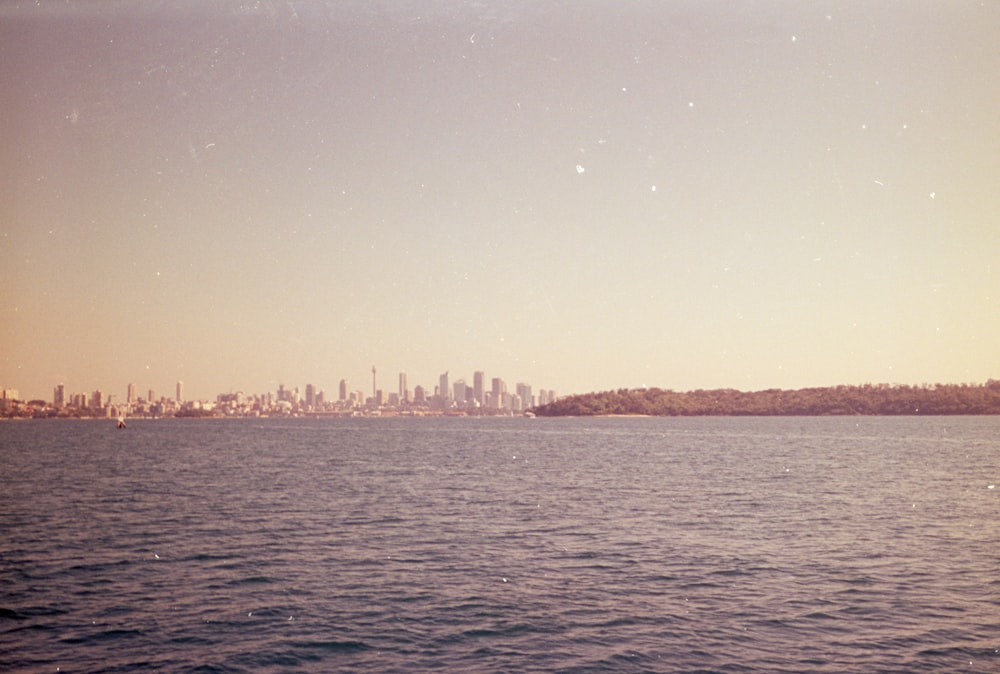 a large body of water with a city in the background