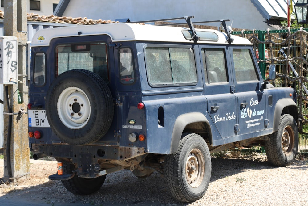 a blue land rover is parked in front of a house