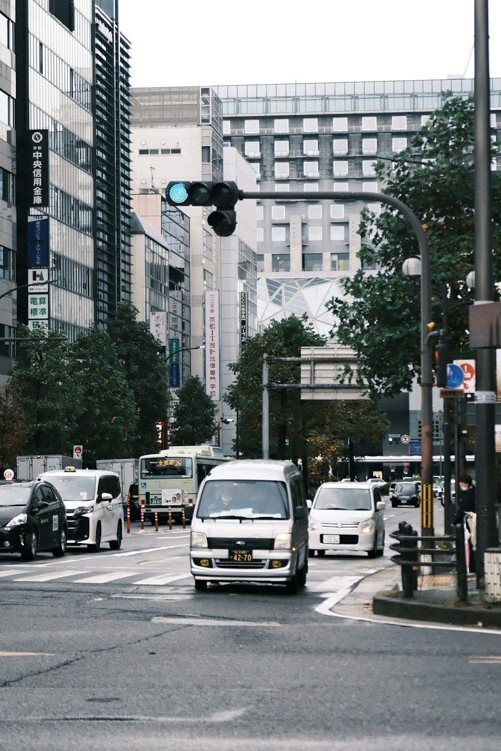 a city street filled with lots of traffic next to tall buildings