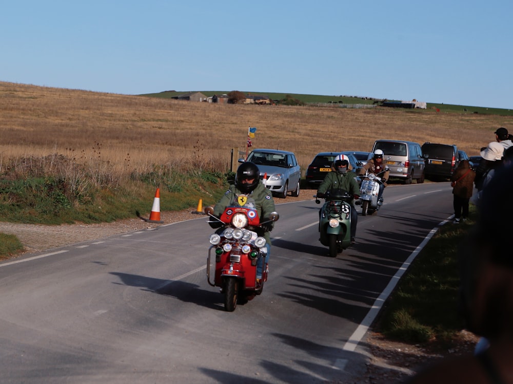 a group of people riding motorcycles down a road