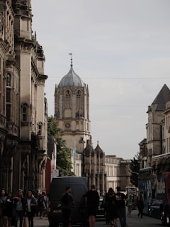 a group of people walking down a street next to tall buildings