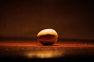 A potato resting in a decorated box with confetti and a small card.