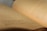A close-up view of an open book with Arabic text. The pages are curved and the focus is on the middle of the book, with the background slightly blurred.