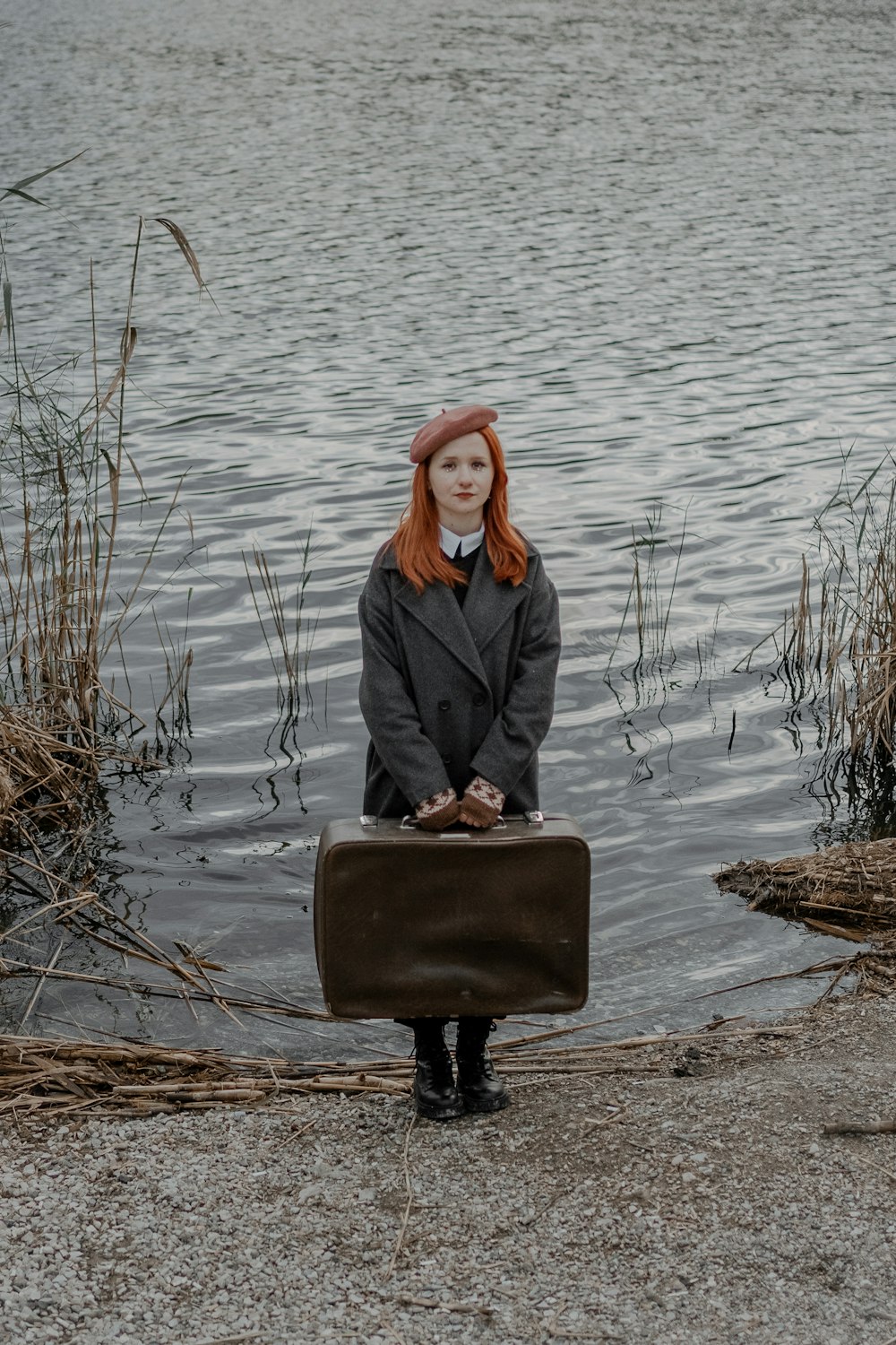 a woman sitting on a suitcase in the water