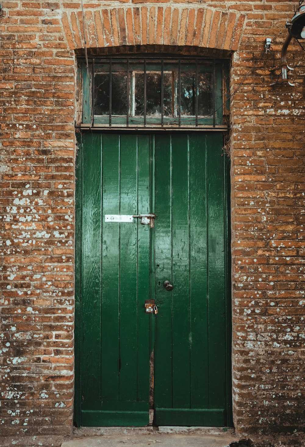 a green door in a brick building