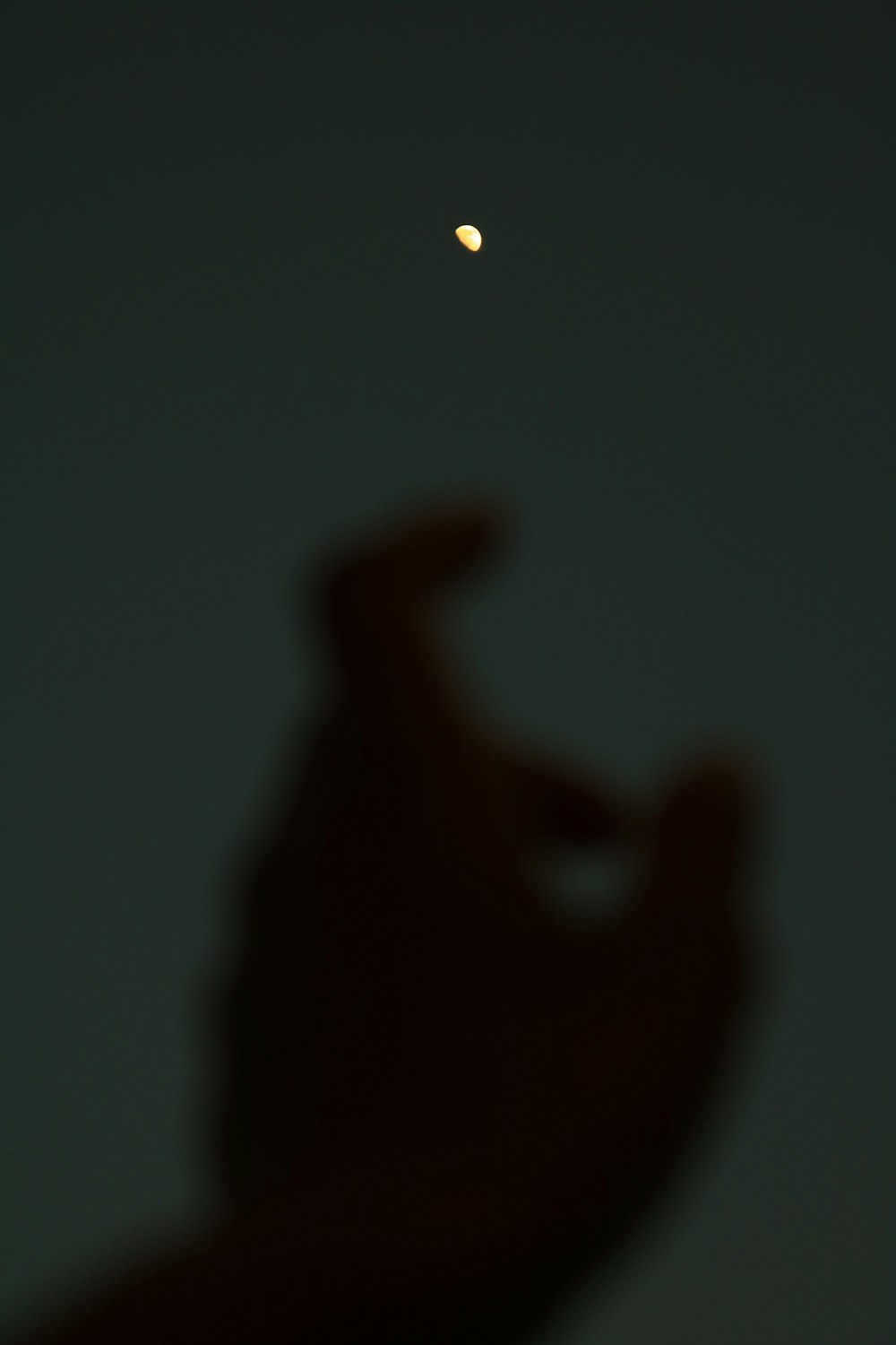 a blurry photo of a person's hand with a half moon in the