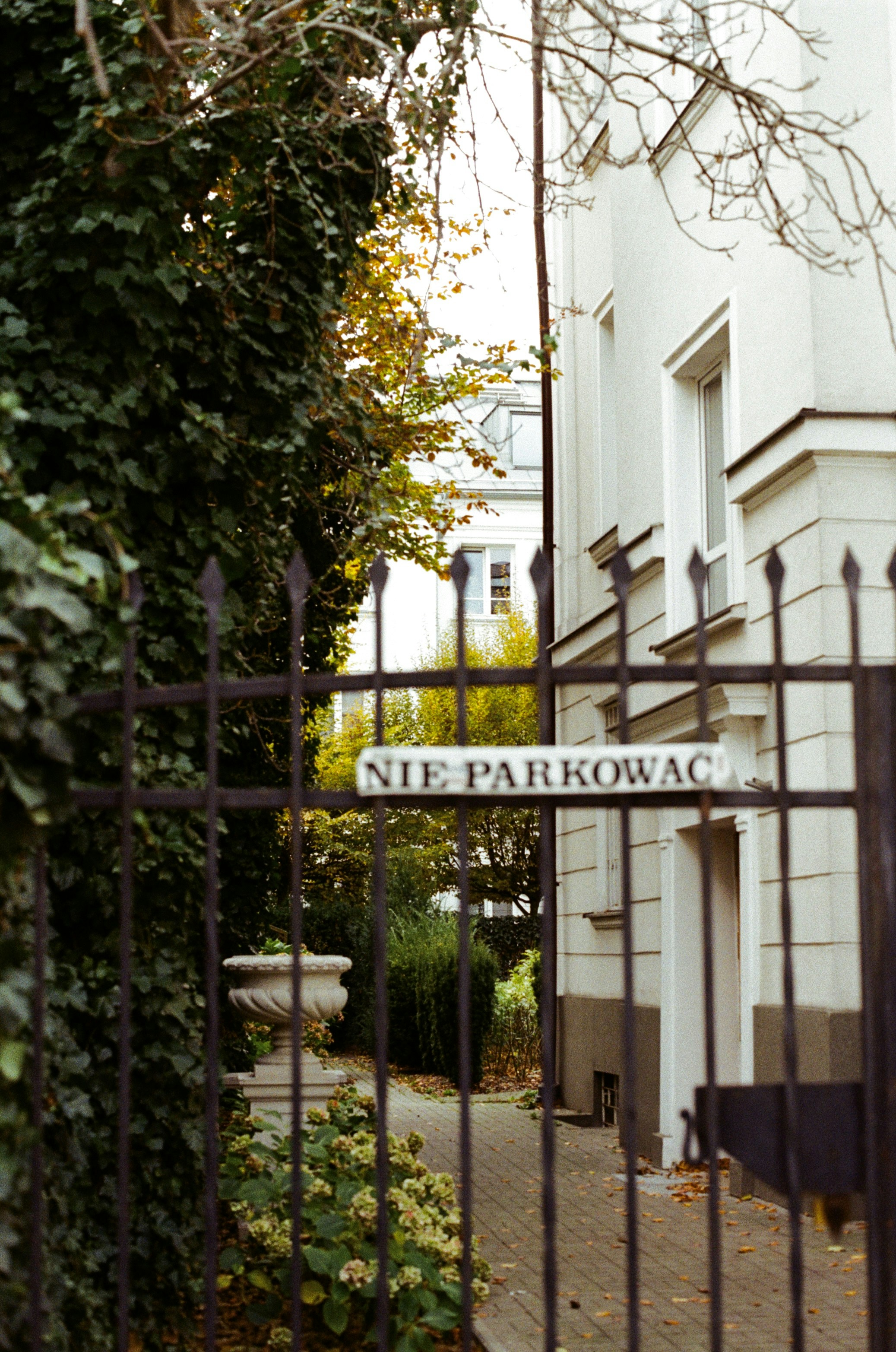 A gated entrance to a building with a street sign photo – Free Street ...