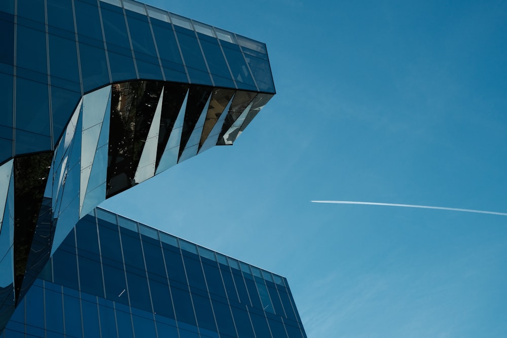 a plane flying in the sky over a building