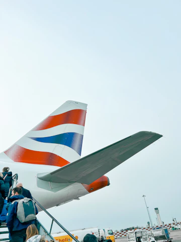 A happy group of travelers boarding a plane with bright blue and turquoise accents in the background.