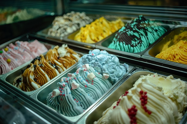 Close-up of colorful gelato tubs neatly arranged in a freezer display.